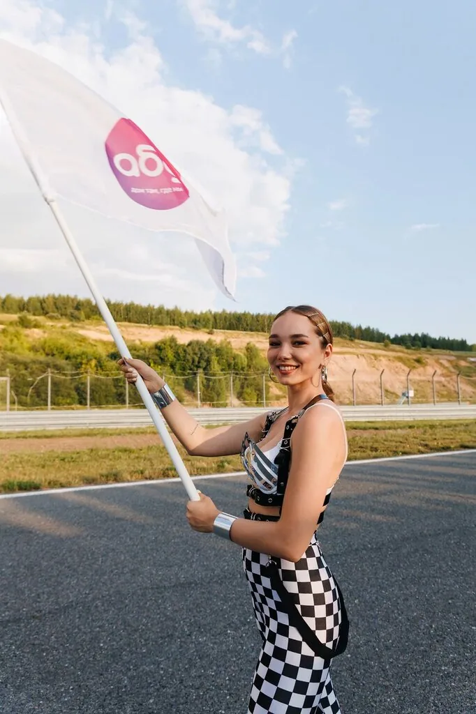 Участница с флагом на старте командных гонок